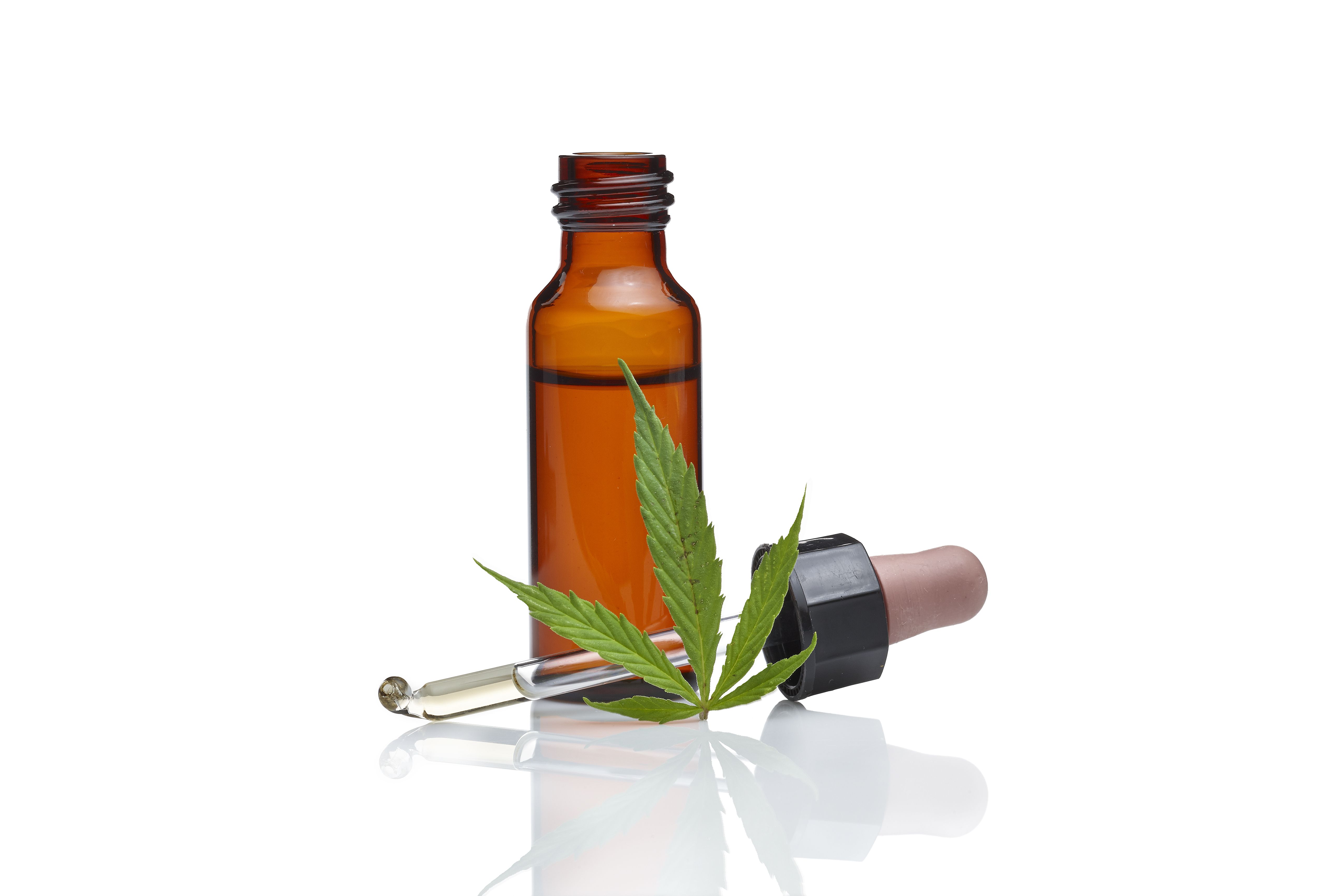 Bouteille d'huile de cannabis avec une feuille de cannabis.