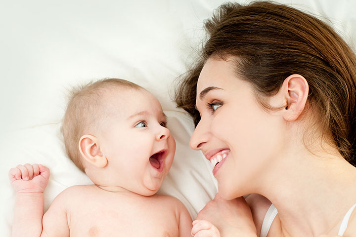 Mère s'amusant avec bébé au lit photos