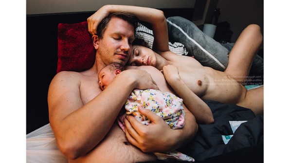 Papa avec nouveau bébé avec maman le serrant dans ses bras