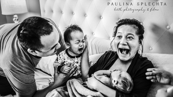 maman souriante tout en tenant un nouveau bébé, papa souriant, un petit garçon qui pleure