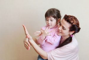 Mère apprenant à la jeune fille à signer 'oiseau' 