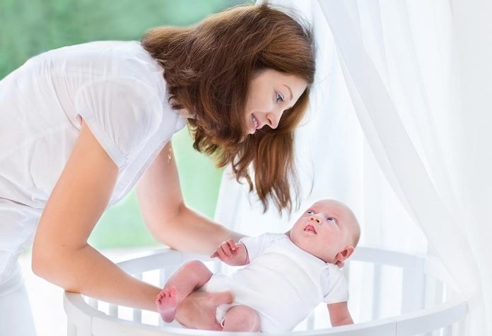 Mère mettant bébé dans un berceau 