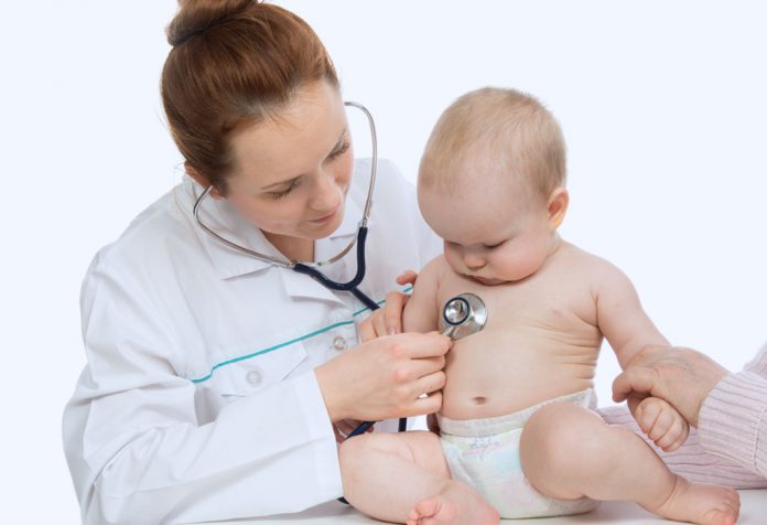 Un médecin vérifiant un bébé avec un stéthoscope Un médecin vérifiant un bébé avec un stéthoscope