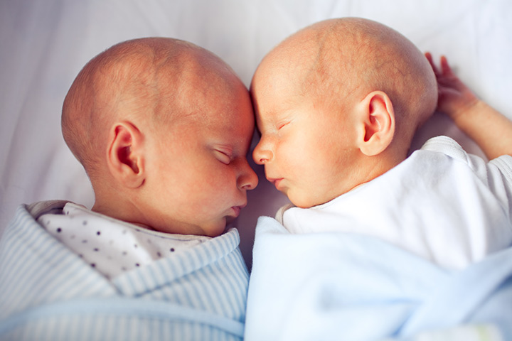Garçon aidant papa à donner un contact peau à peau à des jumeaux prématurés