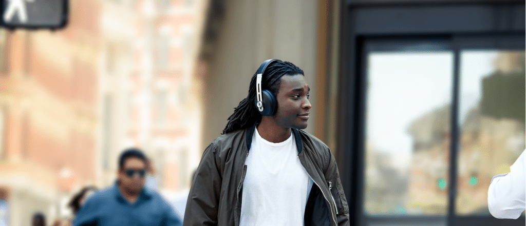Le bonheur sonore de l'équipe autistique par excellence: des écouteurs antibruit 7 Jeune homme noir, environ 30 ans, avec des dreadlocks marchant dans une ville animée tout en portant des écouteurs antibruit