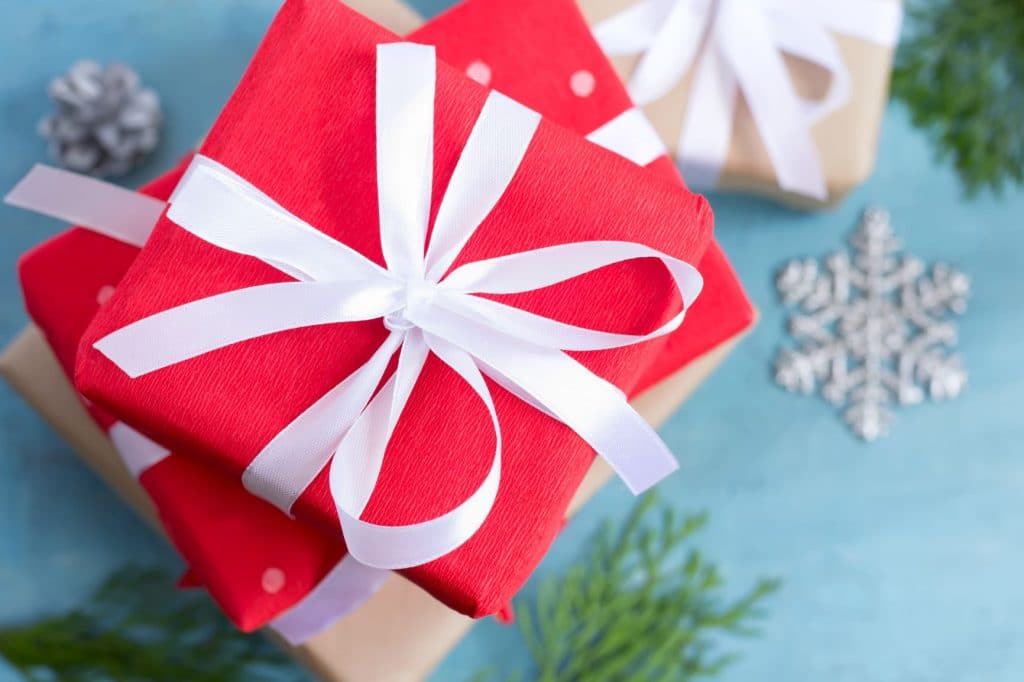 Les vraies raisons pour lesquelles les personnes autistes sont stressées pendant la période des fêtes 8 cadeaux rouges avec un fond blanc sur un papier bleu