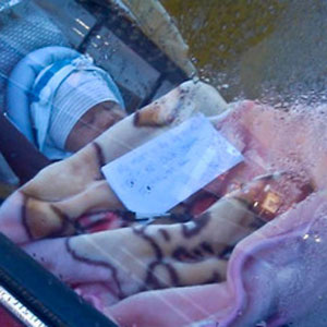 Maman laisse bébé dans la voiture avec note pendant qu'elle fait ses courses