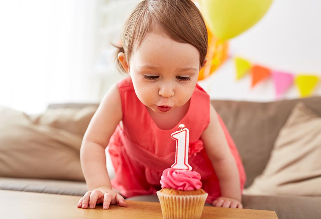 Votre bébé de 12 mois Croissance et développement 5 Une fille d'un an soufflant de sa bougie d'anniversaire
