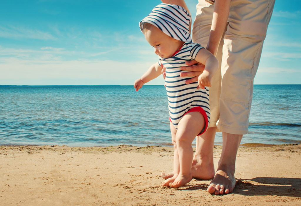 Un petit garçon marchant sur la plage avec son père