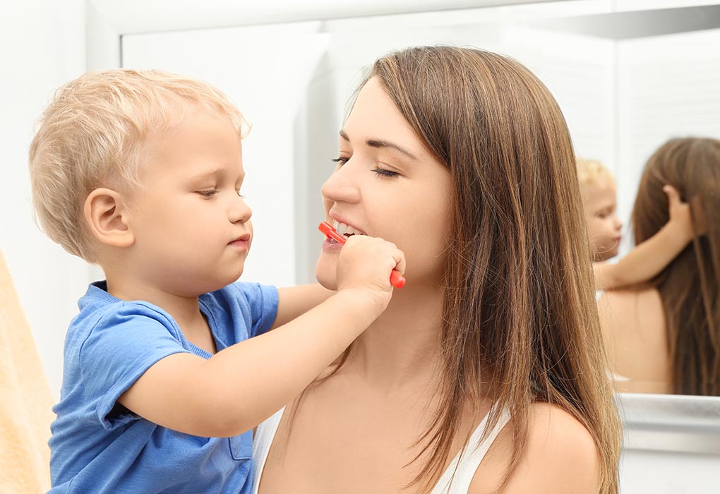 Netter Junge putzt die Zähne seiner Mutter 