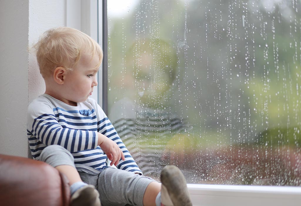 Ein kleiner Junge starrte durch das Fenster auf den Regen